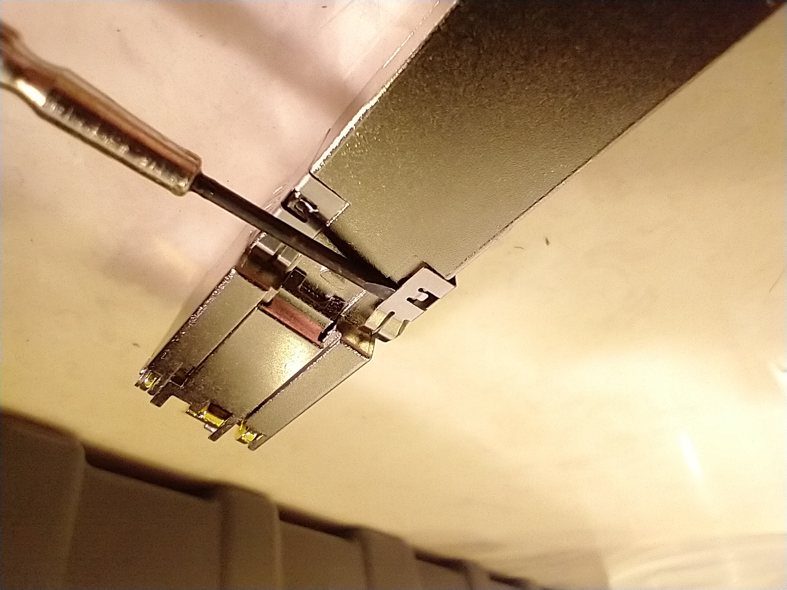 Putting a screwdriver under the other part of the clip